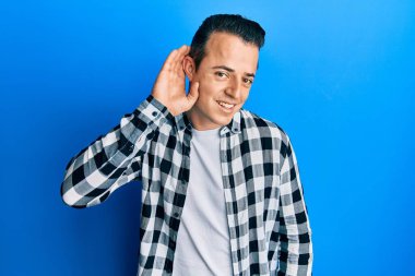 Yakışıklı, rahat gömlekler giyen, kulağı kulağında gülümseyen dedikoduları ve dedikoduları dinleyen genç bir adam. Sağırlık kavramı. 