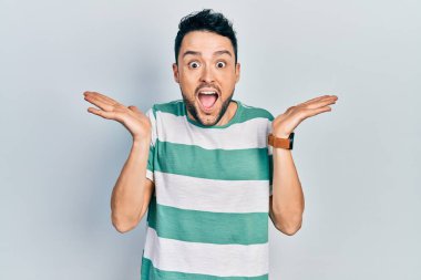 Sıradan kıyafetler giyen genç İspanyol adam çılgın ve başarıyı kollarını kaldırıp heyecanla haykırarak kutluyor. Kazanan konsept 