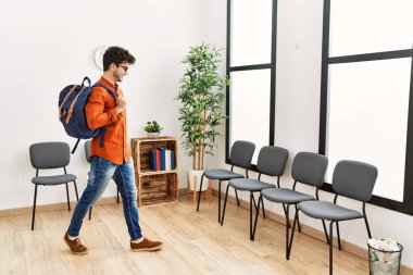 Bekleme odasında sırtüstü sırtüstü sırtüstü gülümseyen İspanyol genç adam