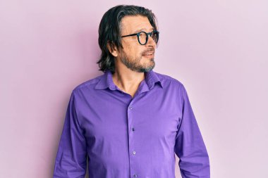 Orta yaşlı, sıradan kıyafetler ve gözlük takan yakışıklı bir adam. Taraf arıyor, rahat profil pozu veriyor. Doğal bir yüzü ve kendine güvenen bir gülümsemesi var.. 