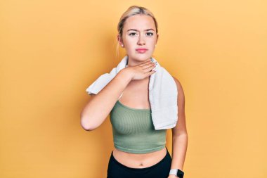 Spor kıyafetleri ve havlu giyen genç sarışın kız bıçak niyetine boğazını kesiyor, saldırganlığı şiddetle tehdit ediyor. 