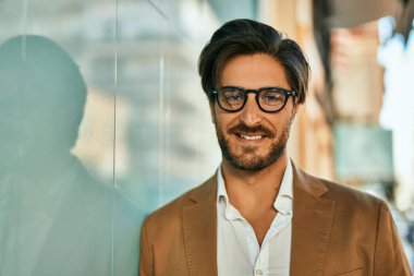 Genç İspanyol işadamı gülümseyerek şehirde mutlu mesut duruyor..