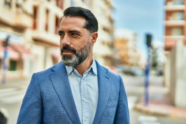 Orta yaşlı işadamı şehirde mutlu mesut dikilirken.