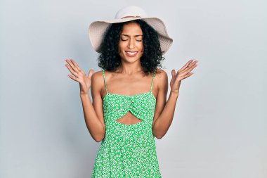 Yaz şapkası takan genç Latin kız başarı için çıldırıyor ve çıldırıyor kollarını kaldırıyor ve gözleri kapalı heyecanla bağırıyor. Kazanan konsept 