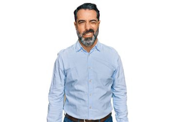 Sakallı, iş gömleği giyen, kameraya seksi bir ifadeyle bakan, neşeli ve mutlu yüzlü orta yaşlı bir adam.. 