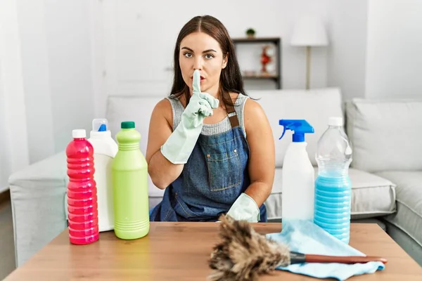 Młoda Brunetka Czystszym Fartuchu Rękawiczkach Sprzątająca Domu Prosząc Ciszę Palcem — Zdjęcie stockowe