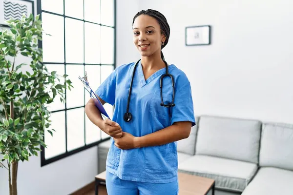 Jovem Afro Americana Trabalhando Vestindo Uniforme Médico Trabalhando Clínica Olhando — Fotografia de Stock