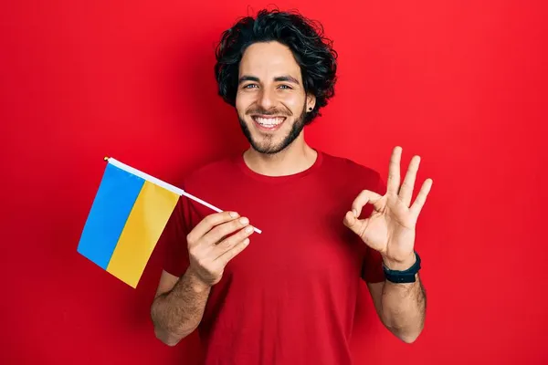 Bonito Homem Hispânico Vestindo Bandeira Ucraniana Fazendo Sinal Com Dedos — Fotografia de Stock