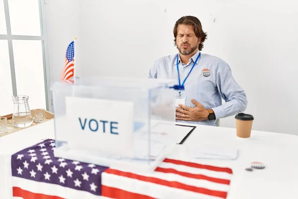 英俊的中年男人坐在投票站里 手放在肚子上 因为消化不良 痛苦不堪 疼痛的概念 — 图库照片