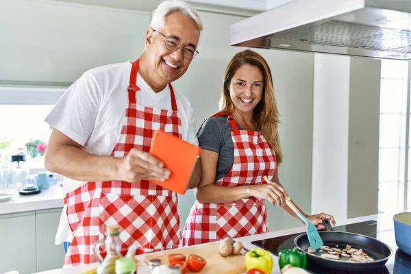 Pareja Hispana Mediana Edad Sonriendo Feliz Cocinando Usando Touchpad Cocina —  Fotos de Stock