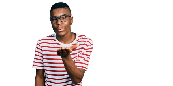 Joven Hombre Afroamericano Vistiendo Camiseta Casual Gafas Mirando Cámara Soplando —  Fotos de Stock