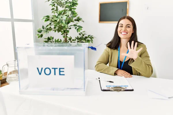 Genç Esmer Kadın Seçim Masasında Oturuyor Pusulasını Gösteriyor Beşinci Parmaklarıyla — Stok fotoğraf