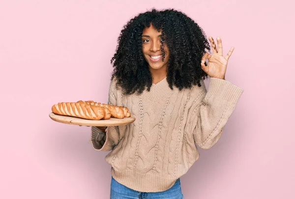 Молода Афроамериканська Дівчина Тримає Тацю Хлібом Робить Гаразд Пальцями Посміхаючись — стокове фото