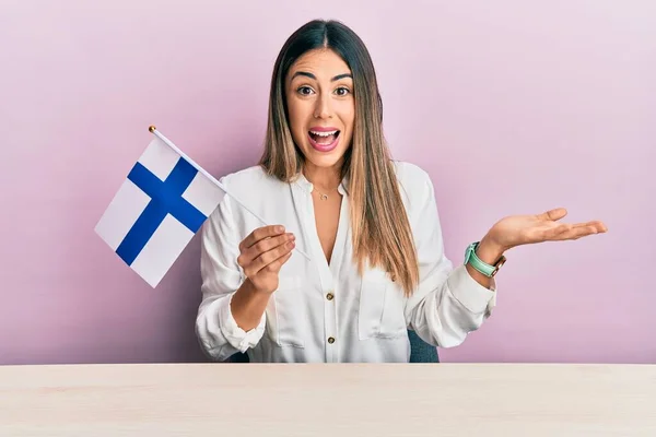 Jonge Spaanse Vrouw Die Vlag Van Finland Vasthoudt Tafel Zit — Stockfoto