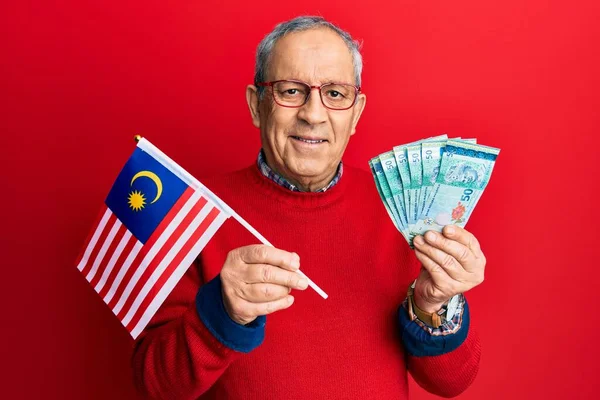 マレーシアの国旗を掲げた白髪の老人と 楽しそうに笑顔で笑顔を見せるマレーシアリンギットの紙幣 歯を見せて — ストック写真