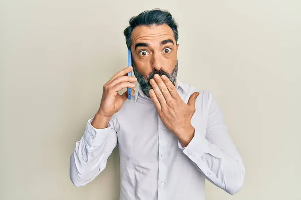 Mężczyzna Średnim Wieku Brodą Siwymi Włosami Rozmawiający Smartfonie Zakrywający Usta — Zdjęcie stockowe