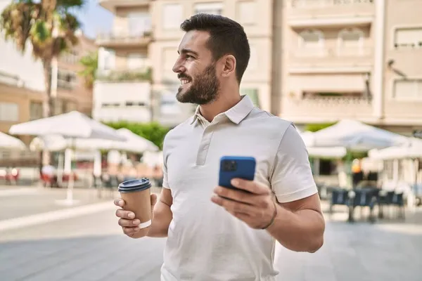 在街上用智能手机喝咖啡的年轻人 — 图库照片