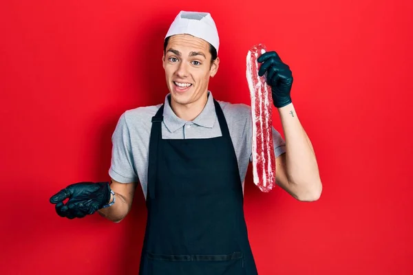 Young Hispanic Man Wearing Cook Apron Holding Meat Celebrating Achievement — Stock Photo, Image