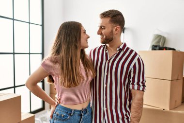 Yeni evinde mutlu gülümseyen beyaz bir çift..