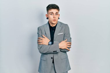 Kulakları genişlemiş, iş ceketi giymiş, kış soğuğundan titriyor ve donuyor. Yüzünde üzgün ve şok ifadesi var. 