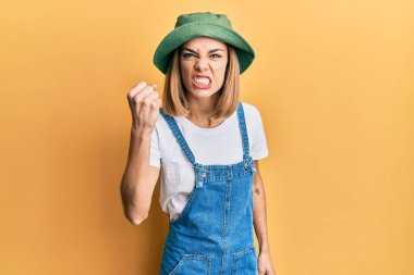 90 'lı yılların tarzında kot tulum ve şapkalı genç, beyaz bir kadın öfkeyle bağırırken yumruk sallıyor ve sinirleniyor. öfke ve agresif konsept. 