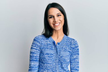 Yüzünde mutlu ve havalı bir gülümseme olan gündelik kıyafetler giyen genç İspanyol kadın. şanslı kişi. 