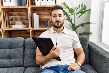 Psikoloji kliniğinde çalışan yakışıklı İspanyol adam yüzünde ciddi bir ifadeyle rahatlamış. Basit ve doğal bir şekilde kameraya bakıyorsun.. 