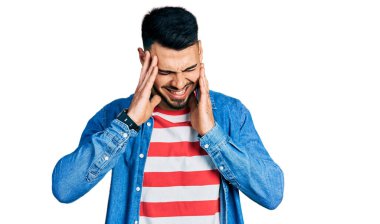 Sakallı, sıradan kot ceket giyen, eli kafasında, başı ağrıyan genç İspanyol bir adam. migren ağrısı. 