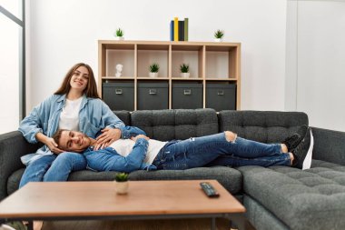 Kafkasyalı genç çift evdeki kanepede rahatça oturuyor..