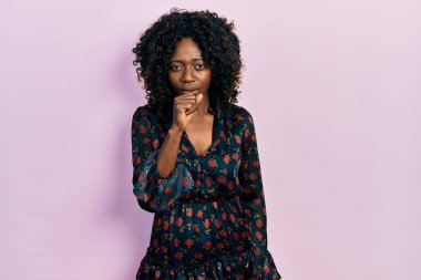 Genç Afro-Amerikalı kadın günlük giysiler giyiyor kendini iyi hissetmiyor ve soğuk algınlığı veya bronşitin belirtisi olarak öksürüyor. sağlık hizmeti kavramı. 