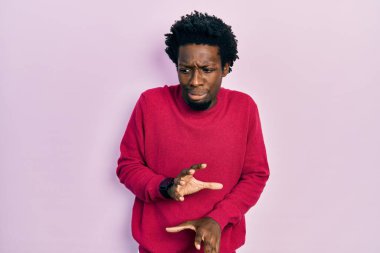 Genç Afro-Amerikan adam günlük giysiler giyiyor, tiksindirici ifadeler takınıyor, tiksindirici ifadeler takınıyor, tiksindirici ifadeler takınıyor.. 