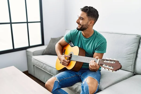 Hombre Árabe Joven Tocando Guitarra Clásica Sentado Sofá Casa — Foto de Stock