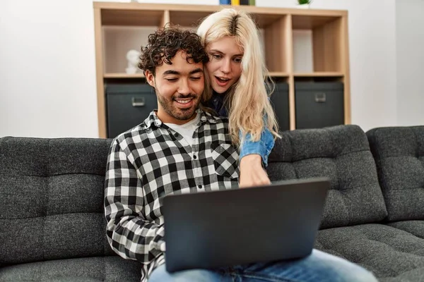 年轻夫妇坐在家里的沙发上 用笔记本电脑 — 图库照片
