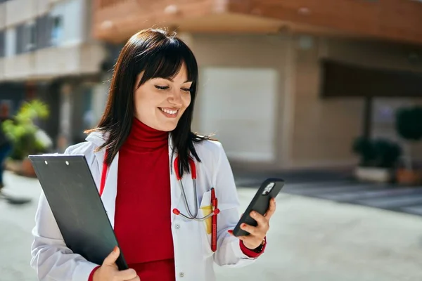 Mujer Morena Joven Vistiendo Uniforme Médico Usando Smartphone Ciudad —  Fotos de Stock