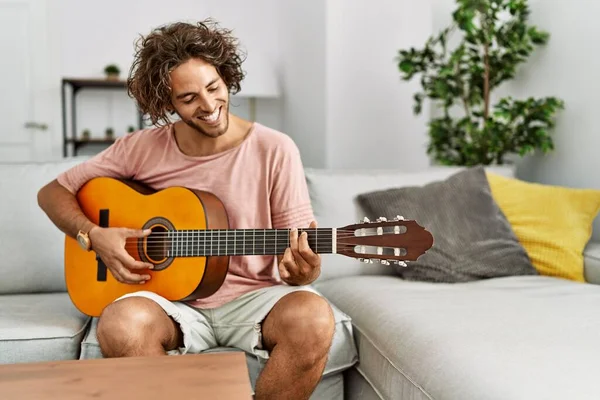 Jovem Hispânico Sorrindo Feliz Tocando Guitarra Clássica Sentado Sofá Casa — Fotografia de Stock