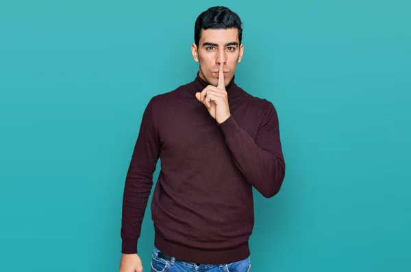 唇に指で静かにするように頼むカジュアルなタートルネックセーターを着たハンサムなヒスパニック系の男 沈黙と秘密の概念 — ストック写真