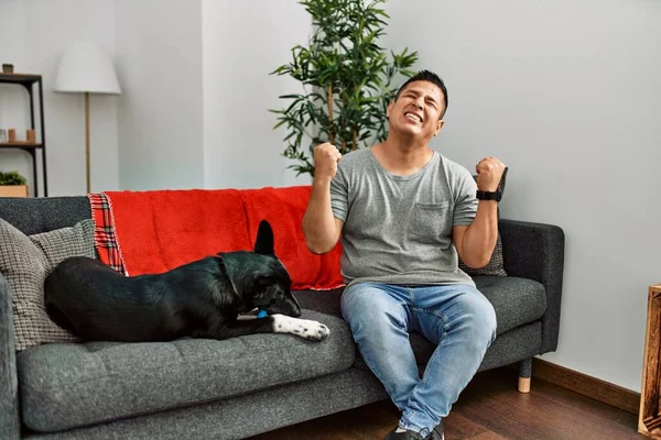 Jovem Latino Cão Sentado Sofá Casa Comemorando Surpreso Surpreso Com — Fotografia de Stock