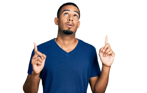 Giovane Uomo Afroamericano Indossa Maglietta Casual Stupito Sorpreso Guardando Alto — Foto Stock
