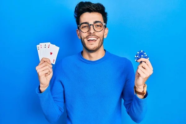 Joven Hispano Jugando Póquer Sosteniendo Fichas Casino Cartas Sonriendo Riendo — Foto de Stock