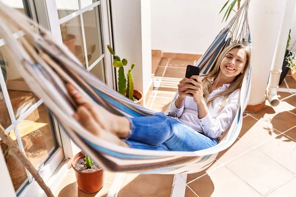 Jovem Loira Usando Smartphone Deitado Rede Terraço — Fotografia de Stock