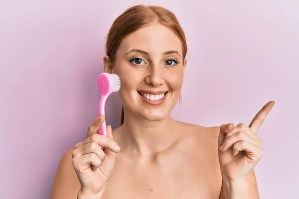 Young Irish Woman Using Facial Exfoliating Brush Smiling Happy Pointing — Stock Photo, Image