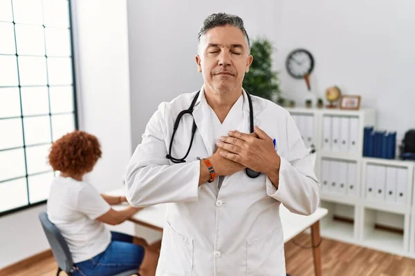Médico Meia Idade Clínica Com Paciente Sorrindo Com Mãos Peito — Fotografia de Stock