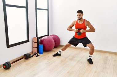 Spor merkezinde çaydanlıkla antrenman yapan genç bir Arap.