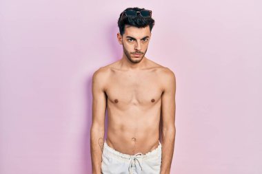 Mayo giyen genç, Latin asıllı, kuşkucu ve gergin bir adam sorun yüzünden surat asıyor. negatif kişi. 