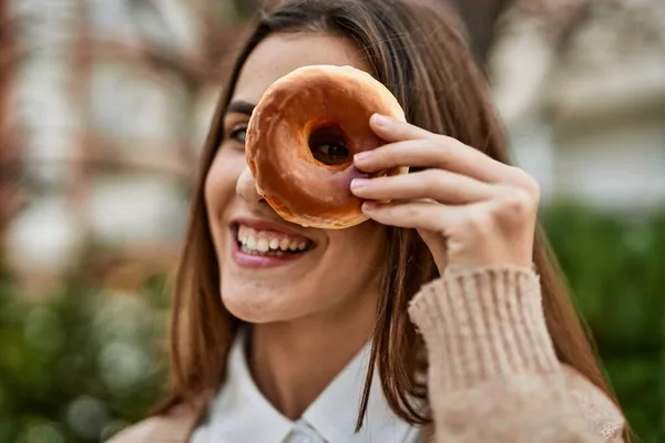 Joven Empresaria Hispana Sonriendo Feliz Sosteniendo Donut Sobre Ojo Ciudad —  Fotos de Stock