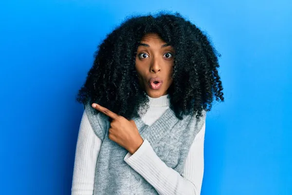 Afroamerykanka Afro Włosy Noszące Swobodny Sweter Zimowy Zaskoczony Wskazując Palcem — Zdjęcie stockowe