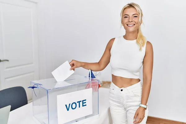 年轻的美国选民笑着高兴地把选票放在选举团的投票箱里 — 图库照片