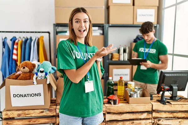 Joven Chica Rubia Vistiendo Camiseta Voluntaria Puesto Donación Señalando Lado —  Fotos de Stock