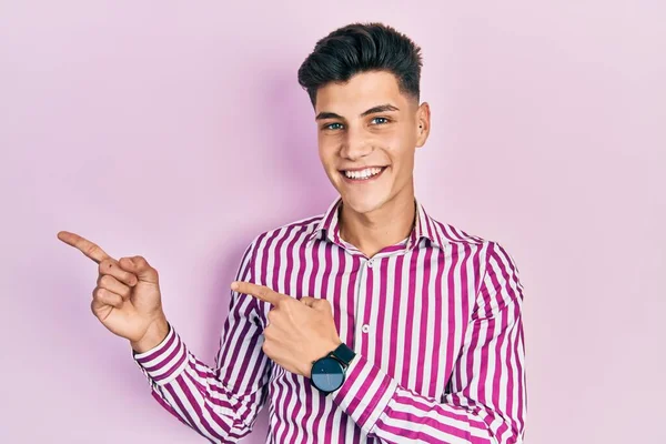 Mladý Hispánec Neformálním Oblečení Usmívá Dívá Kameru Ukazující Oběma Rukama — Stock fotografie