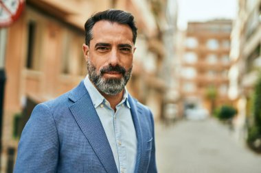 Şehirde duran rahat yüzlü orta yaşlı iş adamı..